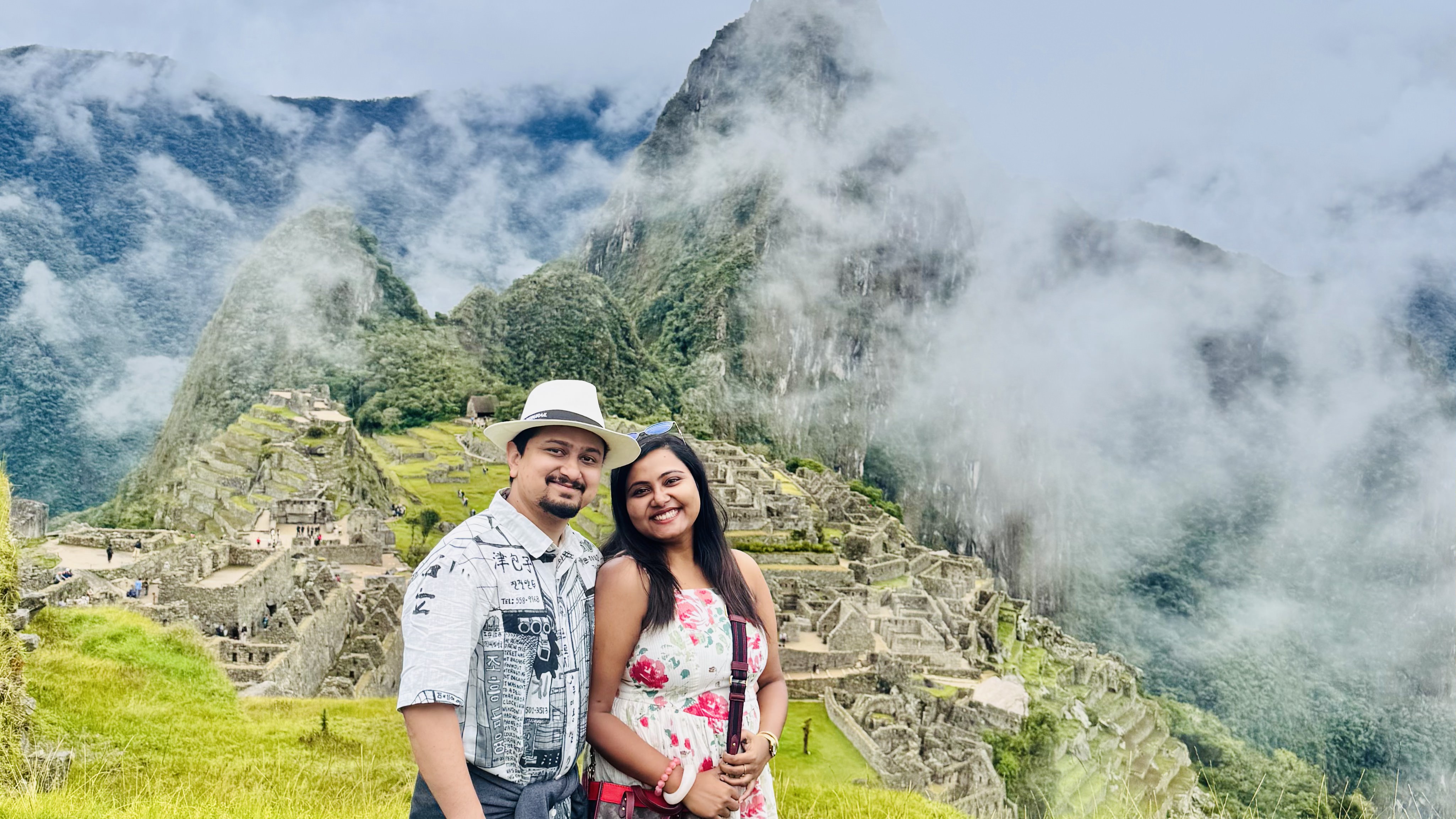 Abhishek and Shreya at Machu Picchu, cloud coming off the peaks